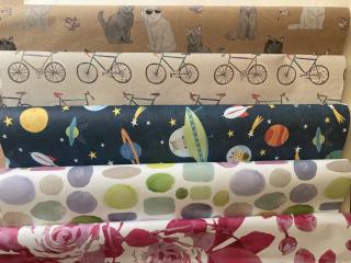 Diverses Geschenkpapier in unterschiedlichen Farben und mit unterschiedlichen Motiven.