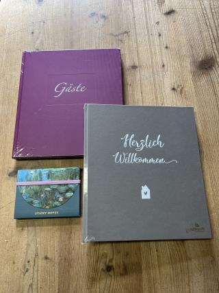 Verschiedenfarbige Gästebücher, sticky notes.