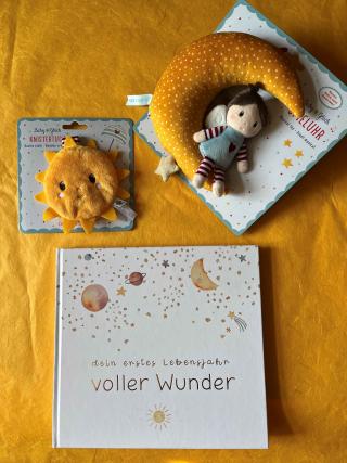 Babytagebuch mit dem Titel Dein erstes Lebensjahr voller Wunder, Knistertuch in Form einer Sonne, Spieluhr in Form eines Mondes mit Stoffpuppe. 