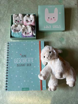Erinnerungsalbum mit dem Titel Deine Geschichte beginnt hier, Plüschschaf, Geschenkbox mit neun Paar Babysocken.