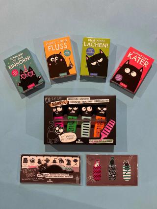 Verschiedene Spiele mit den Titeln Schnapp dir das Einhorn, Stadt, Land, Fluss, Bloß nicht lachen!, Schwarzer Kater. Haftmarker, Textmarker und Lesezeichen mit Motiven von Ed, the Cat.