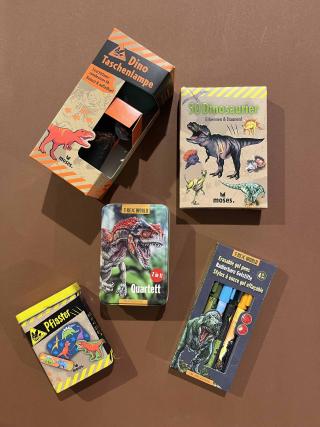 Dino-Taschenlampe, Dino-Pflaster, Quartett-Spiel Dinosaurier, Bestimmungskarten 50 Dinosaurier, radierbare Gelstifte mit Dino-Motiven.