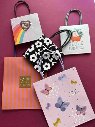 Verschieden große Geschenksackerl mit unterschiedlichen Motiven und Sprüchen.